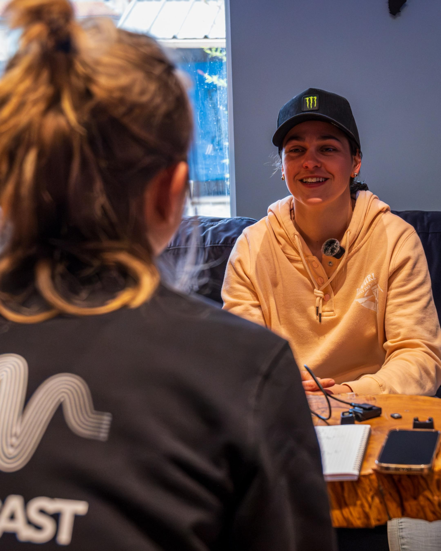 Invitée souriante avec une casquette noire pendant l'enregistrement d'un épisode
